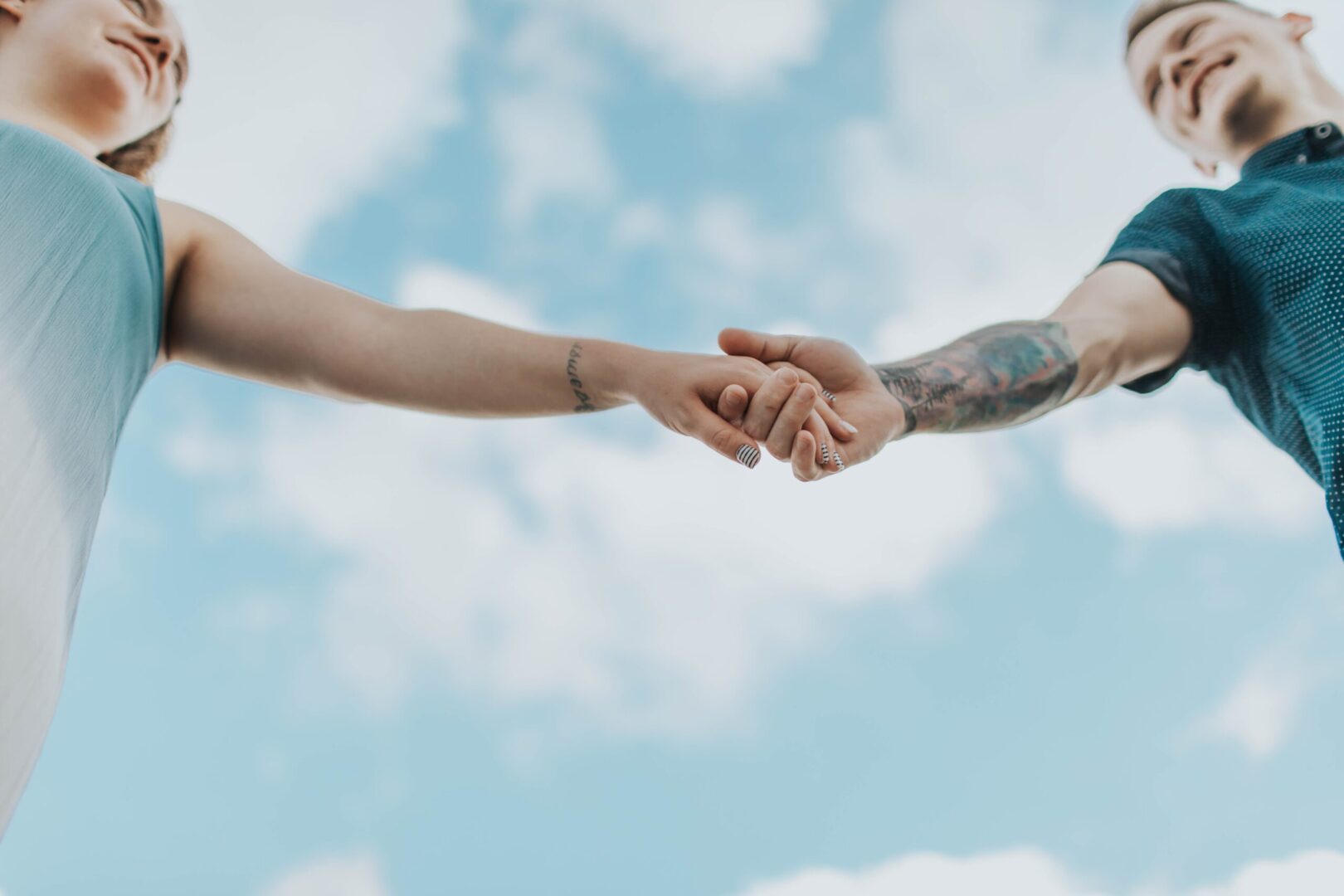 Two people holding hands in the sky